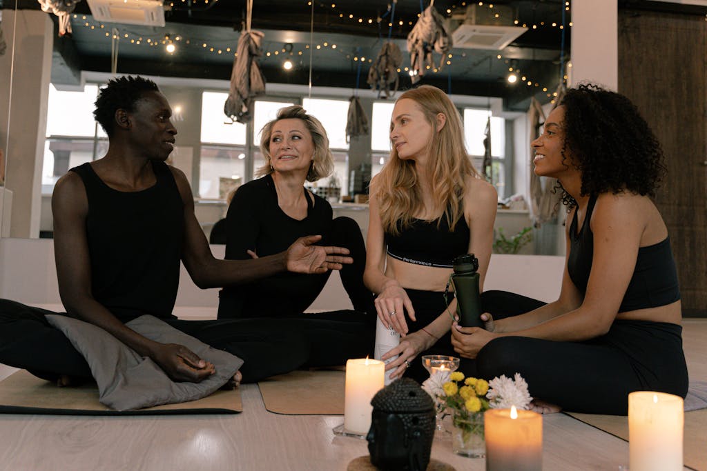 A diverse group of adults engaged in relaxation and meditation in a cozy yoga studio setting.